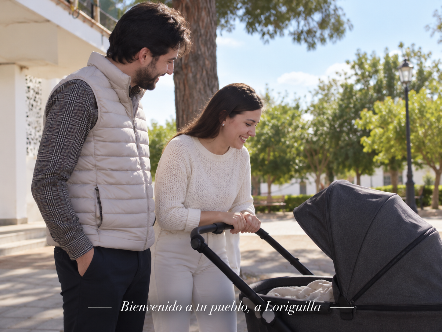 Pareja con un carrito de bebé en una calle de Loriguilla. Detalle de bienvenida a las familias.
