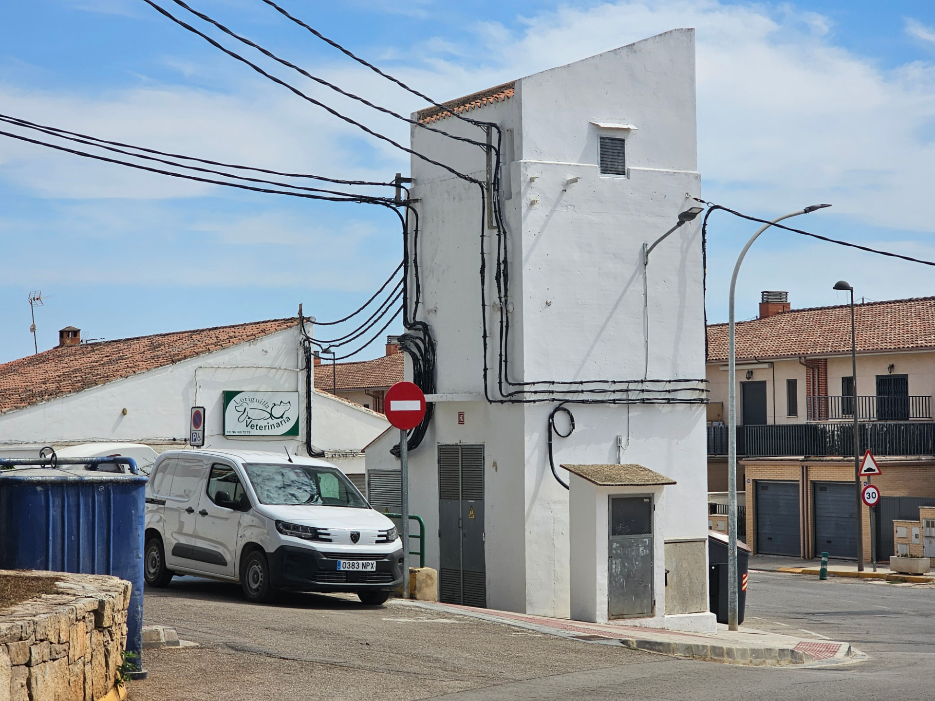 Centro de transformación eléctrica con el cableado de la red en su fachada.