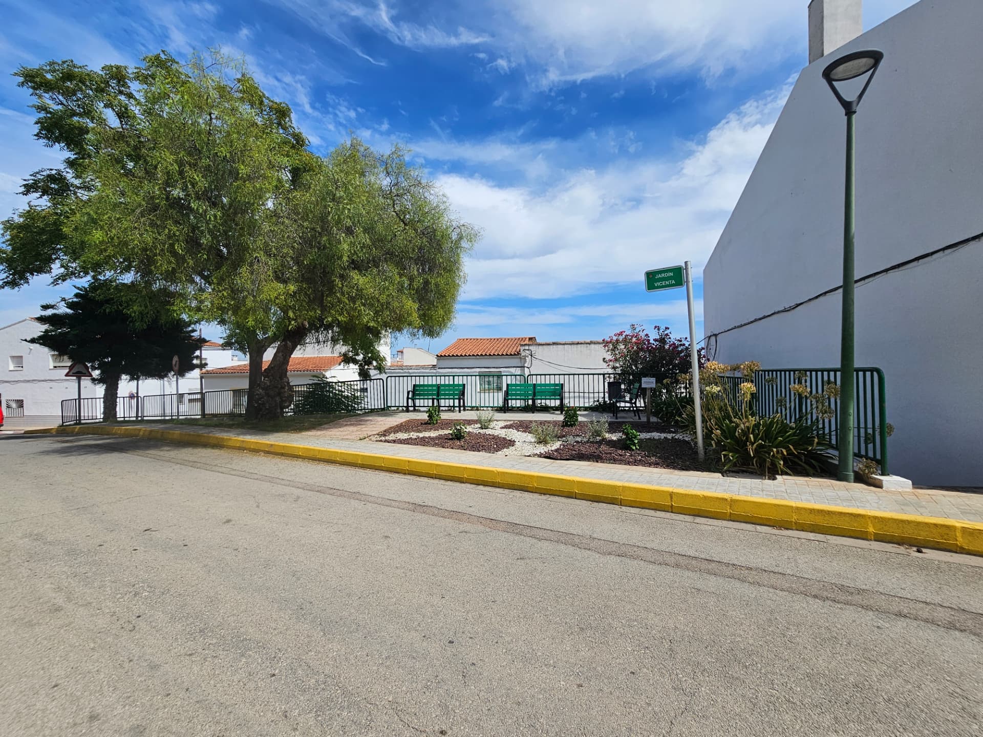 Jardín Vicenta con bancos, vegetación y barandilla de protección.